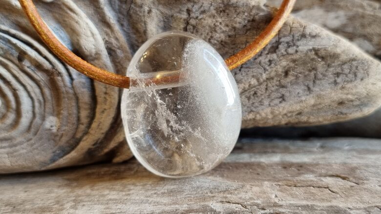 Kalnu kristāla kulons "Laba diena" nr 5. Izmērs 3 x 2 cm Ar brūnu ādas auklu Ar dabīgiem iekļāvumiem