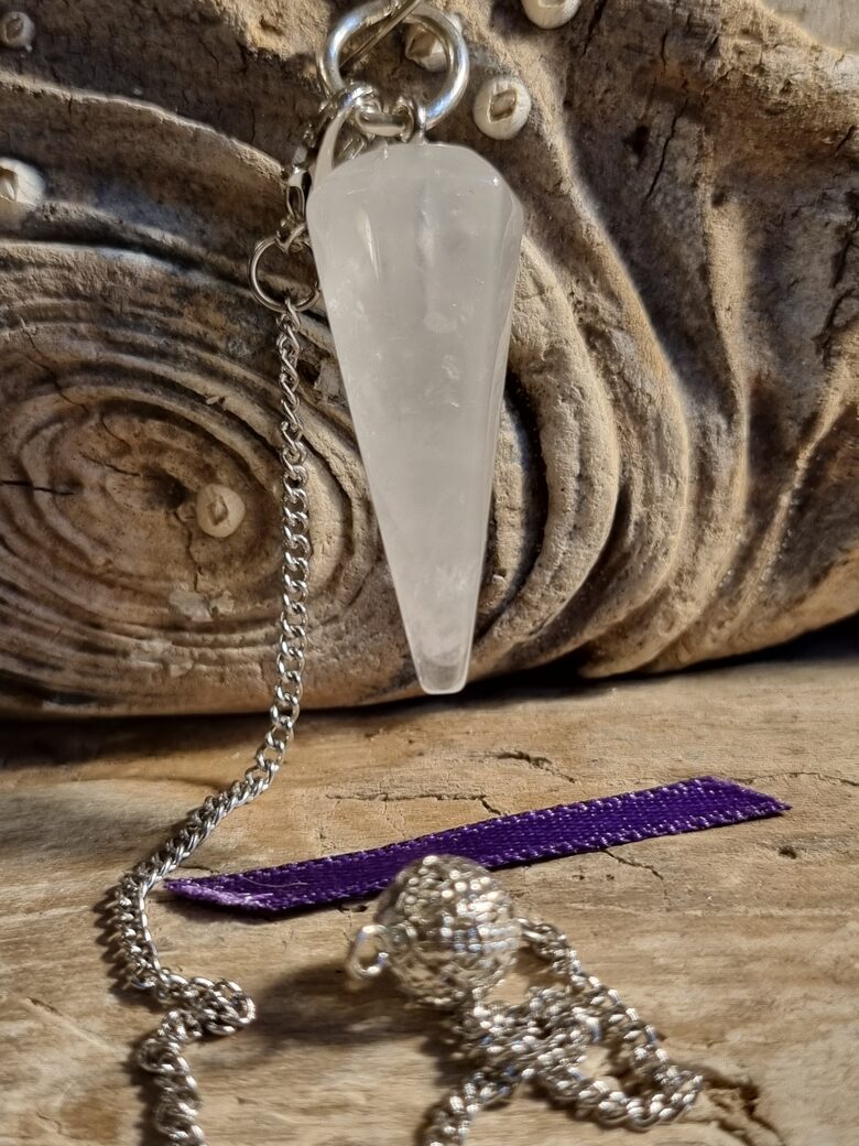 Kalnu kristāla svārstiņš "Slīpētais" nr 3. Izmērs 3 x 1.2 cm Lillā bantīte Ar dabīgiem iespiedumiem