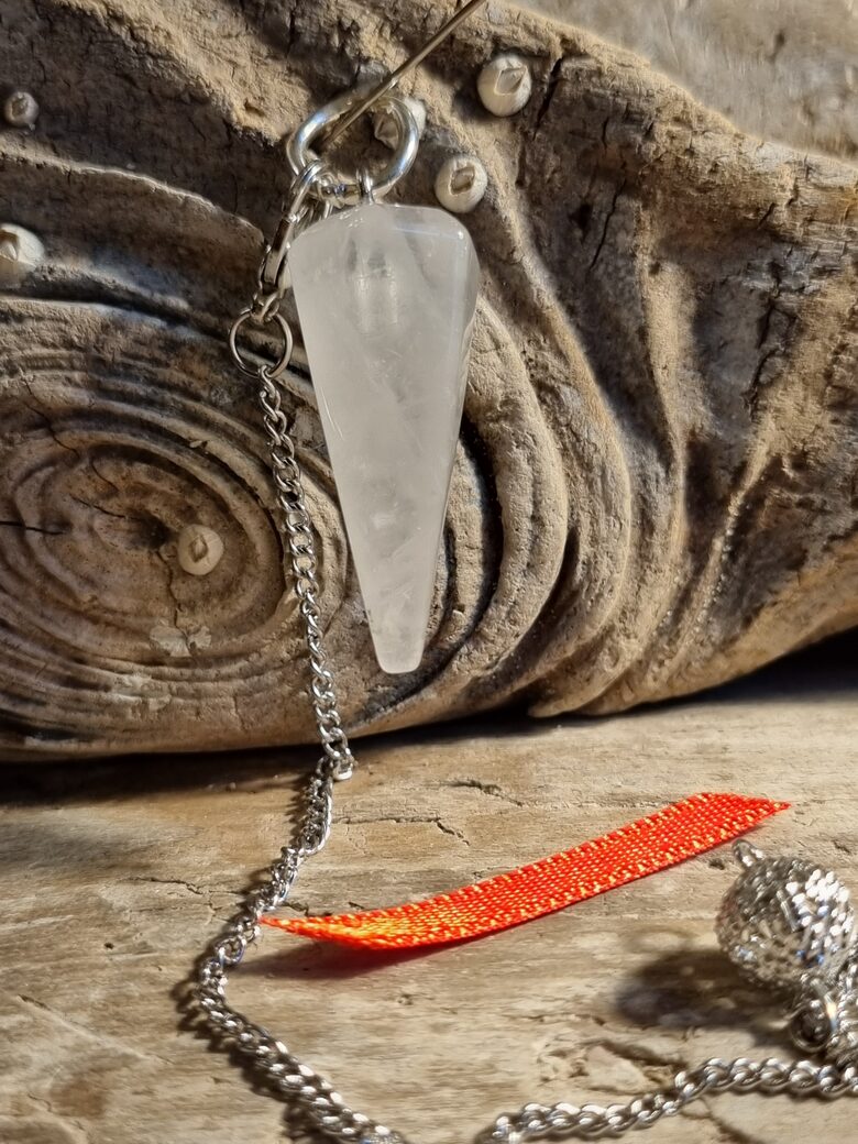 Kalnu kristāla svārstiņš "Slīpētais" nr 4. Izmērs 3 x 1.2 cm Sarkana bantīte Ar dabīgiem iespiedumiem