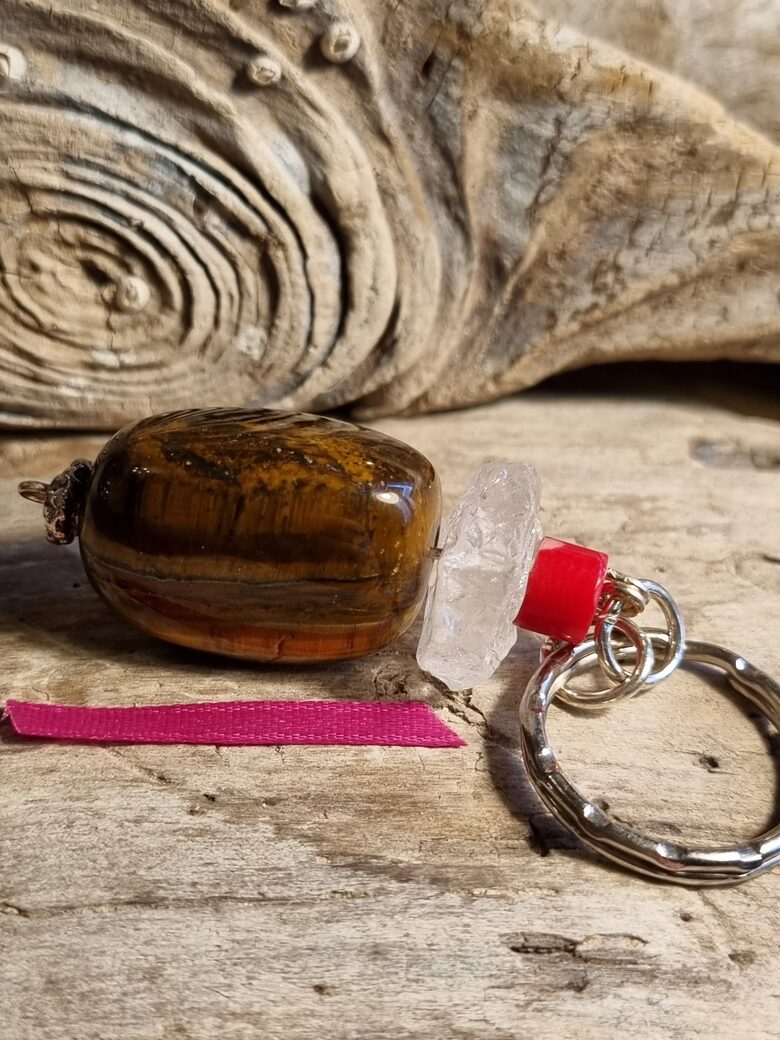 Atslēgu piekariņš ar tīģeraci, kalnu kristālu un koralli Izmērs 5 x 2.5 cm Sārta bantīte