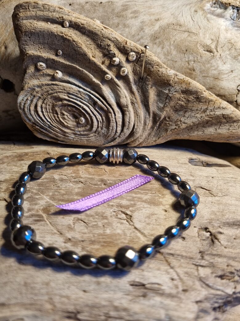 Hematīta aproce "Stiprai aizsardzībai" nr 3. Izmērs 18.5 cm Sudraba krāsas detaļas Lillā bantīte Bumbiņa 5 mm