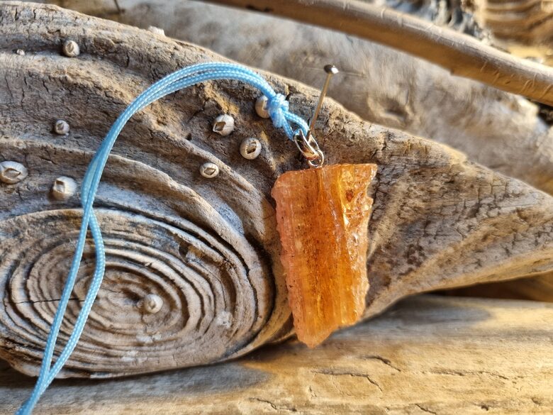 Liels zeltainā topāza kulons neapstrādāts Izmērs 3 x 2.5 cm Ar zilu auklu No Brazīlijas