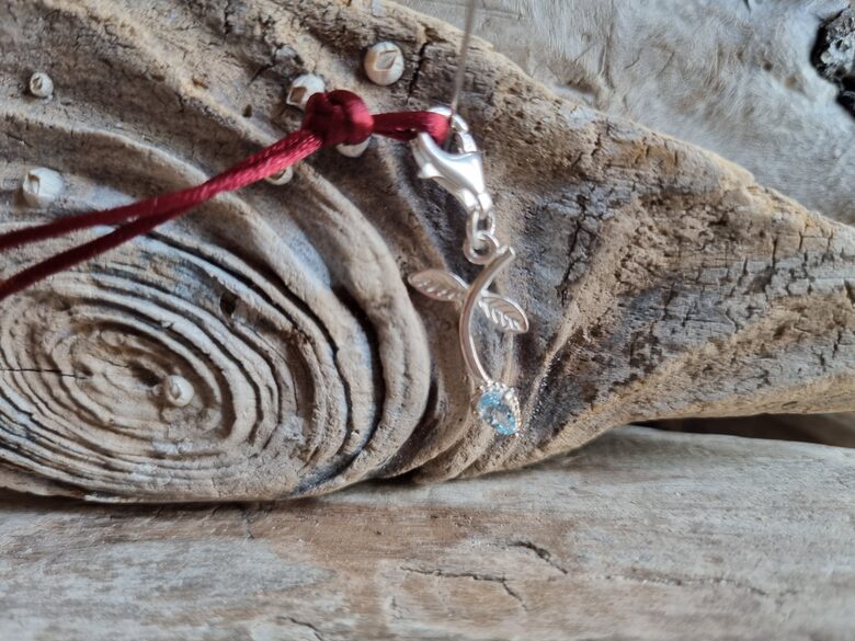 Zila topāza kulons "Prieks" nr 2. Izmērs 3 x 1.3 cm Ar bordo auklu 