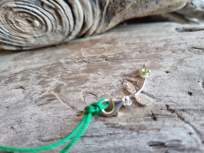 Peridota kulons "Puķīte" nr 1. Izmērs 3 x 1.5 cm Ar zaļu auklu