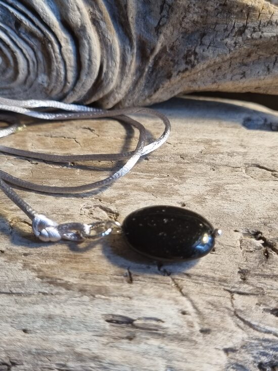 Oniksa kulons "Plakanais" nr 3. Izmērs 2 x 1.3 cm Ar pelēku auklu No Brazīlijas