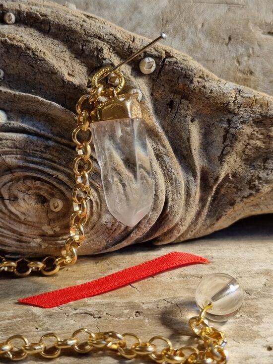 Kalnu kristāla svārstiņš "Enerģijas deva" nr 4. Izmērs 3 x 1 cm Sarkana bantīte Ar dabīgiem iespiedumiem