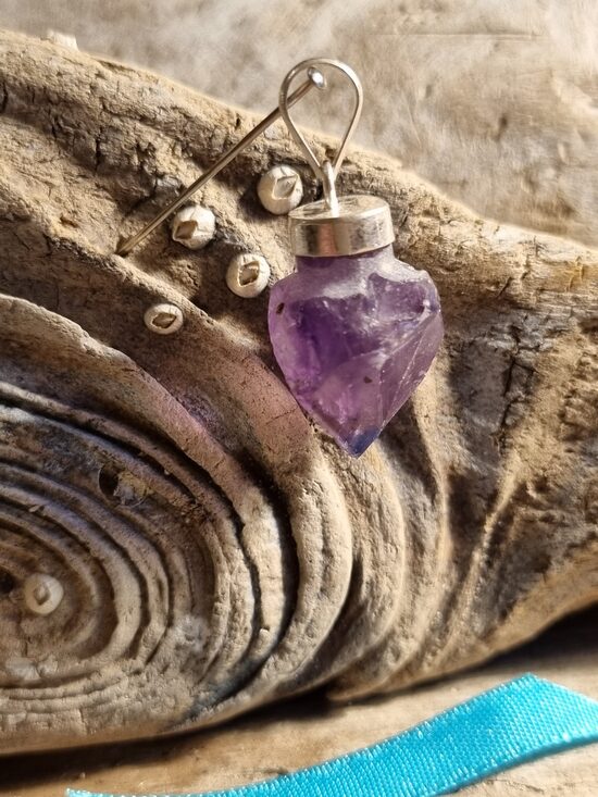 Neapstrādāts ametista kulons "Skaistais" Izmērs 2 x 1.5 cm Zila bantīte Ar dabīgiem iespiedumiem Sudrabs