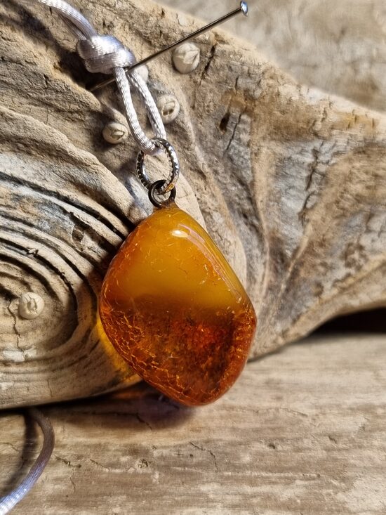 Dzintara kulons "Saule" ar pelēku auklu Izmērs 3 x 2 cm Aizsargamulets 