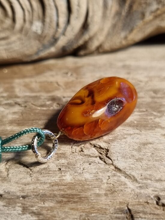 Dzintara kulons "Mans noslēpums" ar zaļu auklu Izmērs 2.5 x 1.2 cm 