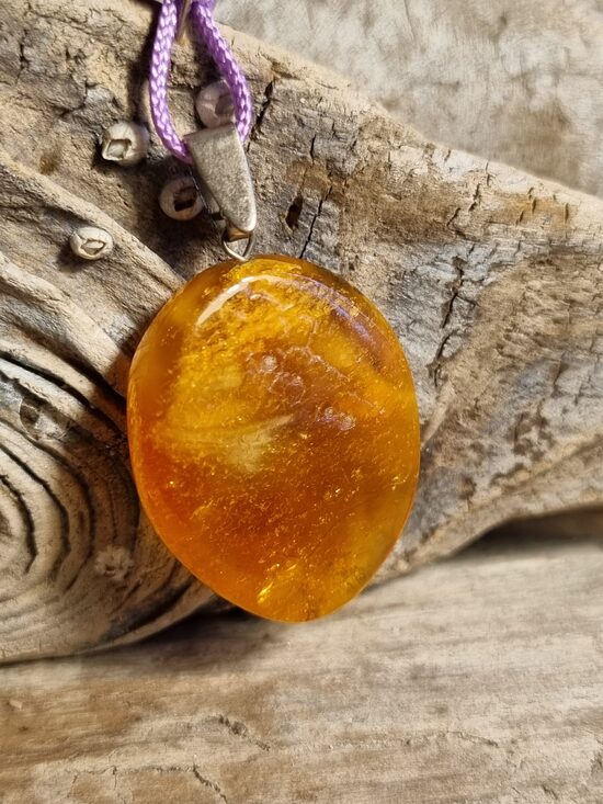 Dzintara kulons "Saulaina diena" ar lillā auklu Izmērs 3.5 x 2.5 cm 