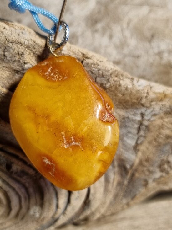 Dzintara kulons "Smaids dienas garumā" ar zilu auklu Izmērs 3 x 2.5 cm