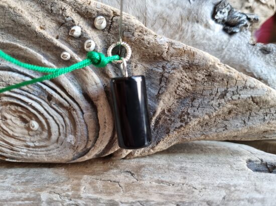 Oniksa kulons "Vienmēr aizsargāts" nr 3. Izmērs 2 x 1 cm Ar zaļu auklu No Brazīlijas