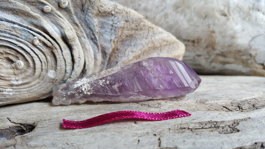 Neapstrādāts ametista kristāls "Attīrošais" nr 3. Izmērs 6 x 1.7 cm Bordo bantīte