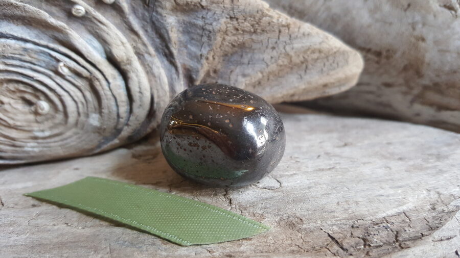 Hematīta olis "Stiprais sargs" nr 2. Izmērs 2.8 x 2 x 2 cm Gaiši zaļa bantīte Ar dabīgiem iedobumiem