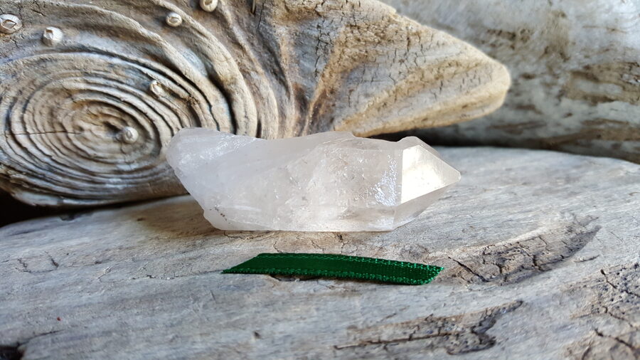 Neapstrādāts kalnu kristāls "Atbalsts biznesā" nr 2. Izmērs 5.5 x 2 x1.5 cm Zaļa bantīte Ar dabīgiem nošķēlumiem un iekļāvumiem