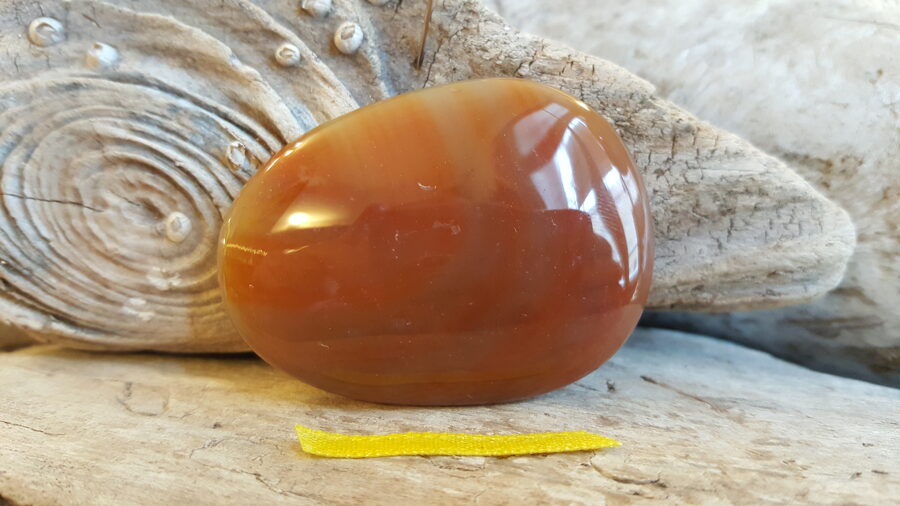 Karneola masāžas lēca nr 4. Izmērs 5 x 3.8 Dzeltena bantīte Lieto sejas masāžai Liek uz ķermeņa