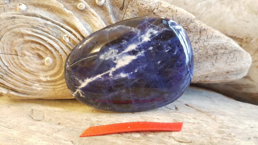 Sodalīta masāžas lēca nr 6. Izmērs 5 x 3.6 cm Sarkana bantīte Lieto sejas masāžai Liek uz ķermeņa