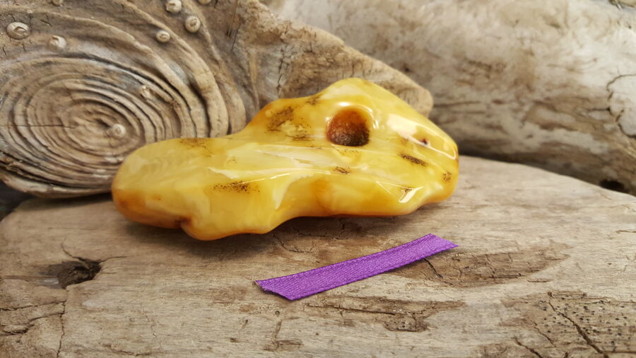 Liels dzintara gabals Daļēji pulēts "Iedvesmas brīdis" Izmērs 8 x 4.5 x 2 cm Lillā bantīte