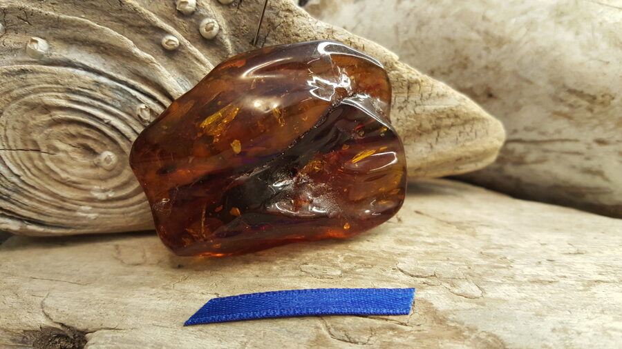 Baltijas dzintara gabals "Ugunīgais spēks" Izmērs 5 x 4 x 1.5 cm Tumši zila bantīte