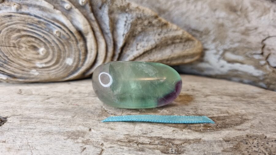 Dabīgs nogludināts fluorīta olis "Skaistais un mierīgais" Izmērs 3.8 x 2 cm Zila bantīte