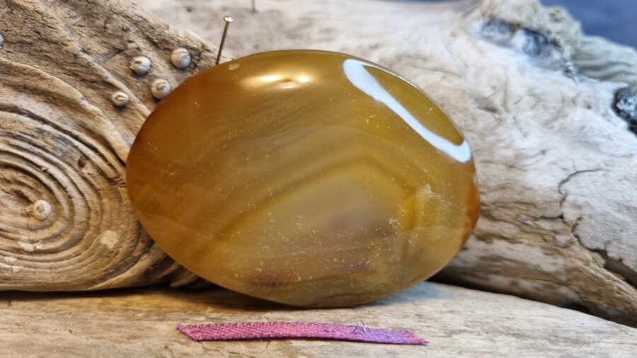 Liels karneols masāžai "Spēka akmens" nr 3. Izmērs 7 x 5 x 1 cm Lillā bantīte Madagaskara  Ar dabīgiem iespiedumiem