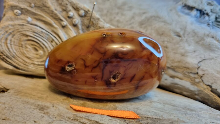 Liels karneols masāžai "Spēka akmens" nr 5. Izmērs 7 x 4 x 3 cm Oranža bantīte Madagaskara  Ar dabīgiem iespiedumiem