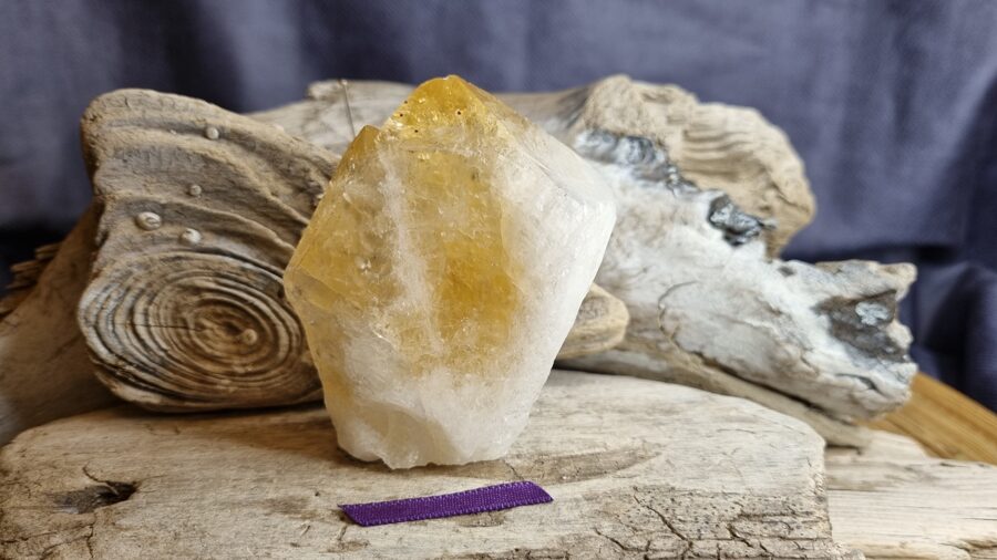 Liels neapstrādāts citrīna kristāls "Pārticības amulets" nr 3. Izmērs 7.5 x 5 x 2.5 cm Lillā bantīte Ar dabīgiem nobrāzumiem Brazīlija
