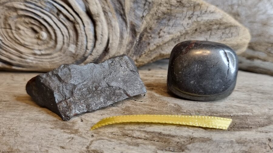 Hematīts "Pārītis" nr 1. Izmērs neapstrādāts 4 x 2 x 1 un olis 2.5 x 2 x 1.5 cm Dzeltena bantīte Ar dabīgiem iespiedumiem