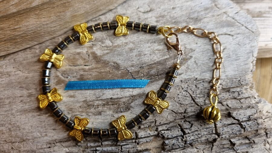 Hematīta rokassprādze "Taurenītis" Izmērs 17 cm Zelta metāls Zila bantīte