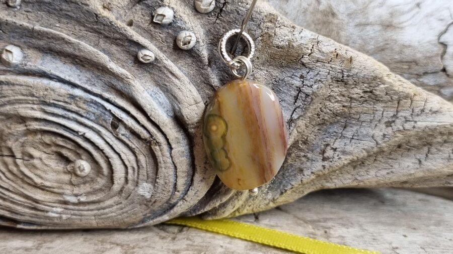 Okeāna jašmas kulons "Aizsargamulets dienas garumā" nr 3. Izmērs 2 x 1.5 cm Dzeltena bantīte No Madagaskaras Sudraba krāsā