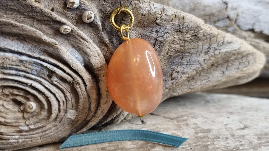 Ahāta kulons "Aprikožu" nr 7. Izmērs 2.5 x 1.8 cm Zelta krāsas metāls Zila bantīte