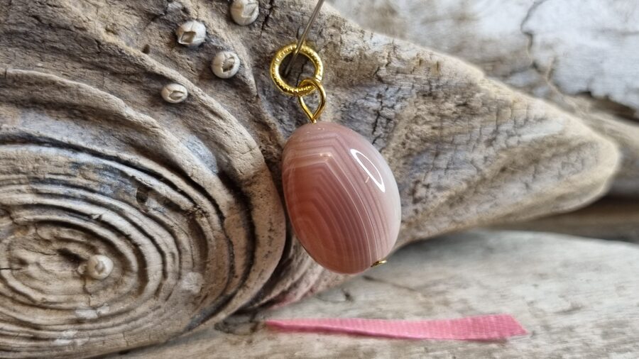 Ahāta kulons "Aprikožu" nr 8. Izmērs 2.5 x 1.6 cm Zelta krāsas metāls Rozā bantīte