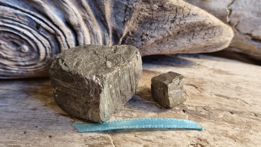 Pirīta kristāli "Liels un mazs" nr 3. Izmērs 2.8 x 2.5 cm un 1 x 1 cm Zila bantīte Uz darba galda vai mājās uz galda Aizsargās