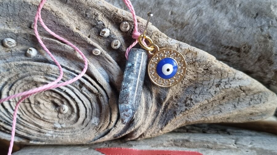 Kianīta kulons ar aizsargaci "Stabilitāte" nr 7. Izmērs 2.8 x 0.6 cm Ar dabīgām švīkām Rozā bantīte