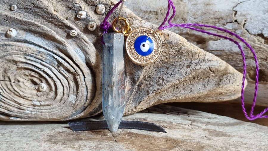 Kianīta kulons ar aizsargaci "Stabilitāte" nr 8. Izmērs 4 x 0.8 cm Ar dabīgām švīkām Pelēku bantīte