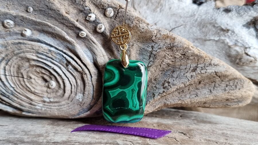 Ekstra klases malahīta kulons "Zaļais aizsargamulets" nr 1. Izmērs 3 x 1.7 cm Lillā bantīte