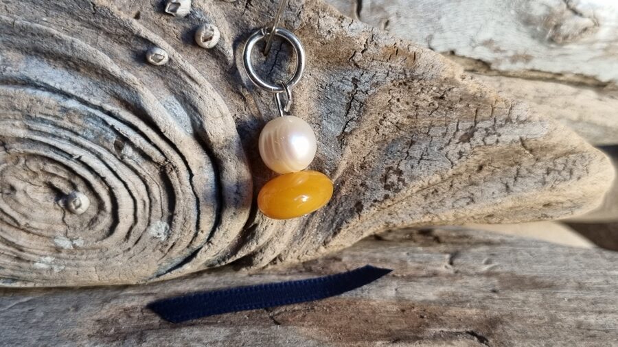 Kulons "Dzintars ar pērli" nr 4. Izmērs 2.5 x 1.3 cm Zila bantīte Der visām zodiaka zīmŗm