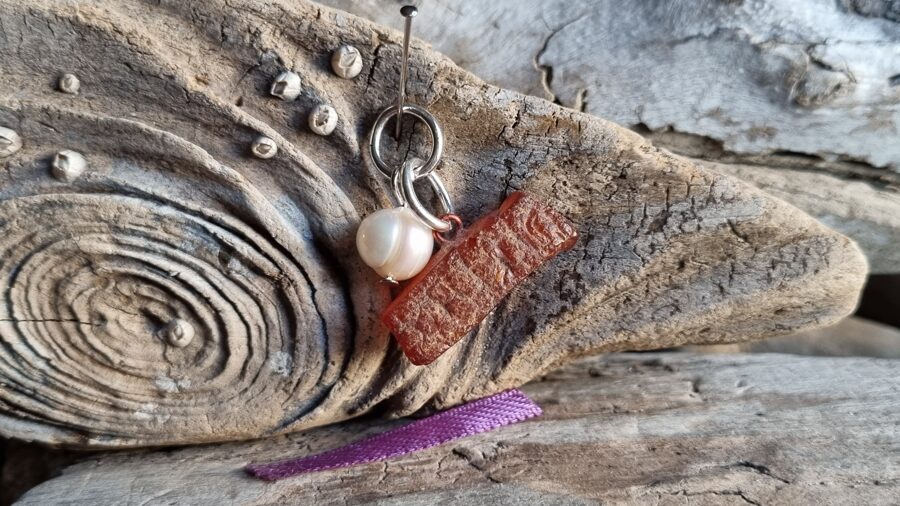 Kulons "Dzintars ar pērli" nr 6. Izmērs 2.5 x 1 cm Lillā bantīte Der visām zodiaka zīmŗm