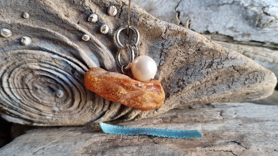 Kulons "Dzintars ar pērli" nr 7. Izmērs 3 x 1.5 cm Zila bantīte Der visām zodiaka zīmŗm