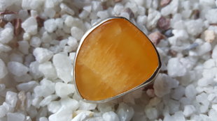 Jaunavu potenciāla amulets - Oranžā kalcīta gredzens 18.5 izmērs. Kalcīts 3.7x3cm. Sudraba krāsas ietvars..