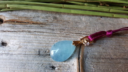Ūdensvīra amulets - Akvamarīna kulons lāsītes formā ar bordo lentīti. Izmērs 2.5 x 1.4 cm. 